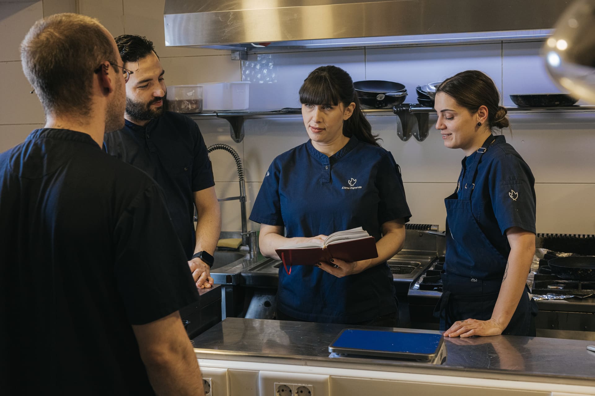 Elena in the kitchen, talking with her team